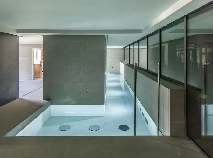Interior d’Art Wellness amb arquitectura minimalista, passarel·la de vidre i espai wellness contemporani.