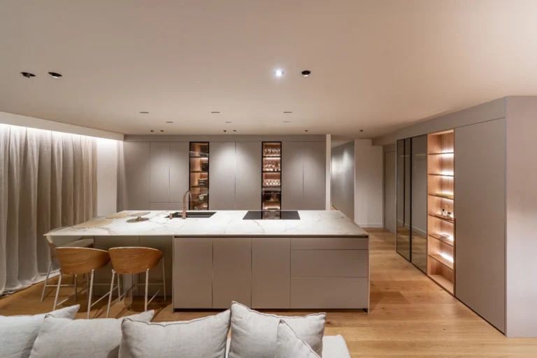 Cuina amb illa central, armaris lacats i vitrines retroil·luminades a l'habitatge rehabilitat als Vilars