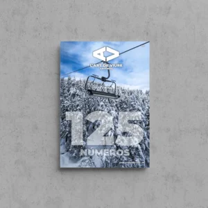 Portada de L'Art de Viure Andorra núm. 125 amb un telecadira sobre un bosc de coníferes nevat i el cel blau, amb la xifra «125 números» sobreimpresa i el nou logotip de la revista.