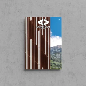 Portada de L'Art de Viure Andorra núm. 128 amb la façana de lames verticals de fusta i pedra de la nova seu de la Justícia, amb el bosc i la muntanya a la dreta, i el logotip de la revista.